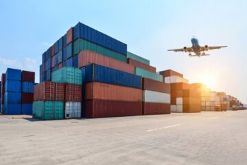 airplane flying on industrial port container yard